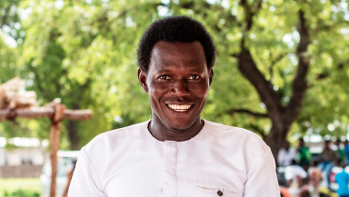 Pastor Laminu holding his Koma Bible at its launch in Ghana in 2024