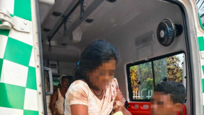 A victim from the attack on Christians in Sadrapal is helped out of an ambulance.