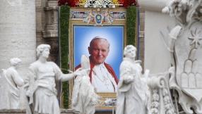 Man who tried to kill Pope John Paul II puts roses on his tomb